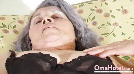 Barnbarn och mormor njuter i sängen och rör vid varandra.