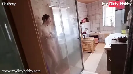 Hij gaat onder de douche staan om haar een goede pijpbeurt te geven en te neuken!
